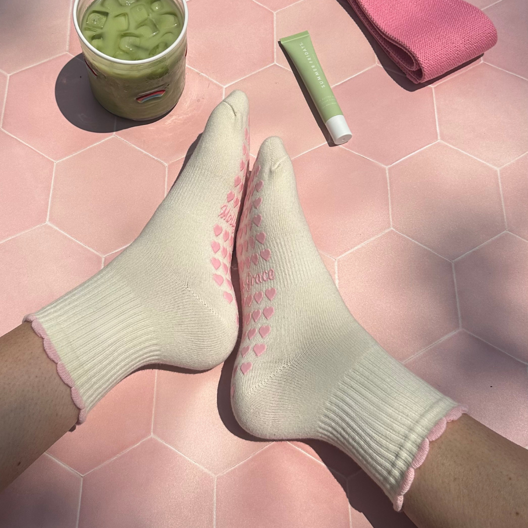 Cream sock with a pink ruffle and pink heart grips